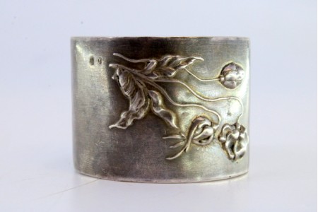 Argola de guardanapo em prata com relevos florais.